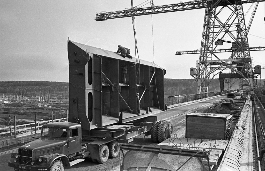 Везут по плотине мощные конструкции, 1968 г.