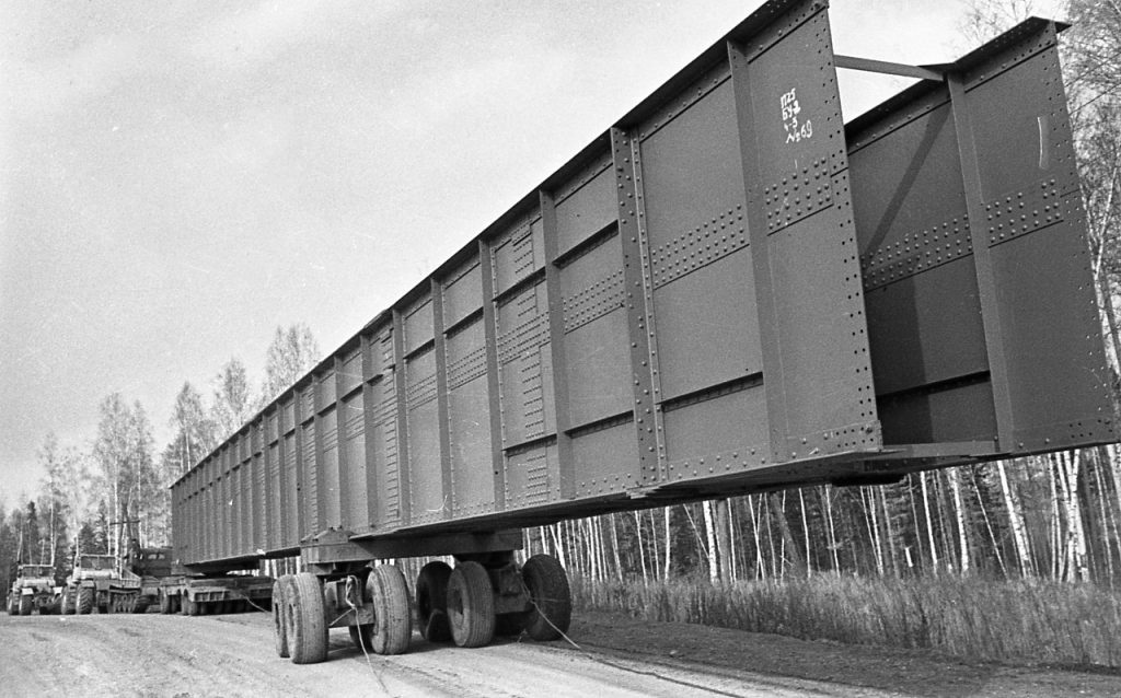 Везут по плотине мощные конструкции, 1968 г.